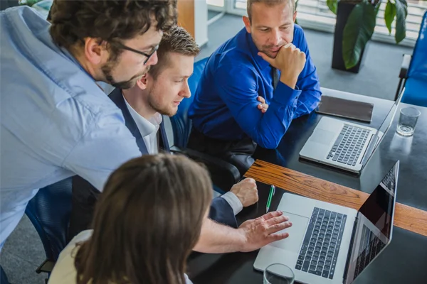 Team collaborating and looking at computer